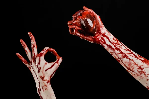 Blood and Halloween theme: terrible bloody hand hold torn bleeding human heart isolated on black background in studio — Stock Photo, Image