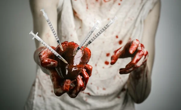 Соціальна реклама і боротьба з наркоманією: залежність від кривавих рук тримає шприц і криваве людське серце — стокове фото