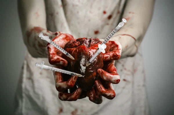 Social advertising and the fight against drug addiction: bloody hands addict holding syringe and bloody human heart — Stock Photo, Image