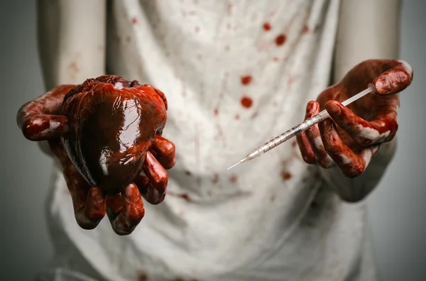 Social advertising and the fight against drug addiction: bloody hands addict holding syringe and bloody human heart