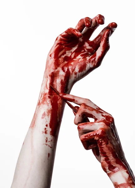 Mano sangrienta con un bisturí, un clavo, fondo blanco, zombi, demonio, maníaco — Foto de Stock