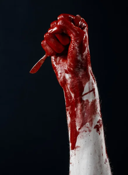 Bloody hand with a scalpel, a nail, black background, zombie, demon, maniac — Stock Photo, Image