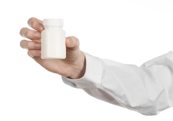 Thème médical : main du médecin tenant un pot blanc vide de pilules sur un fond blanc — Photo