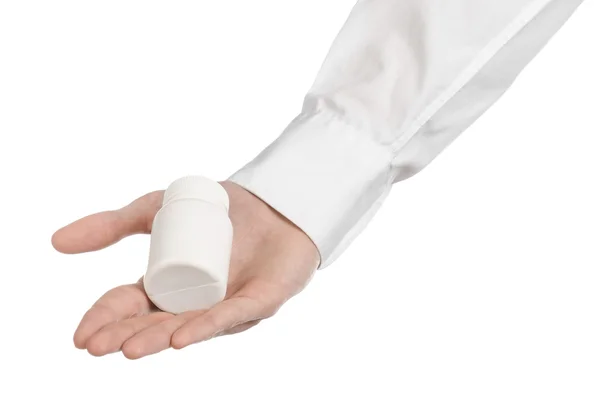 Medische thema: doctor's hand met een witte lege pot van pillen op een witte achtergrond — Stockfoto