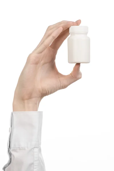 Tema médico: la mano del médico sosteniendo un frasco blanco vacío de pastillas sobre un fondo blanco — Foto de Stock
