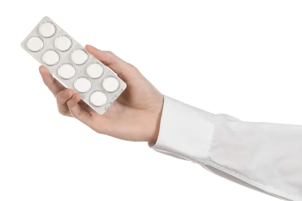 Lékařská téma: za ruku drží bílou tabletu pro zdraví na bílém pozadí, samostatný — Stock fotografie