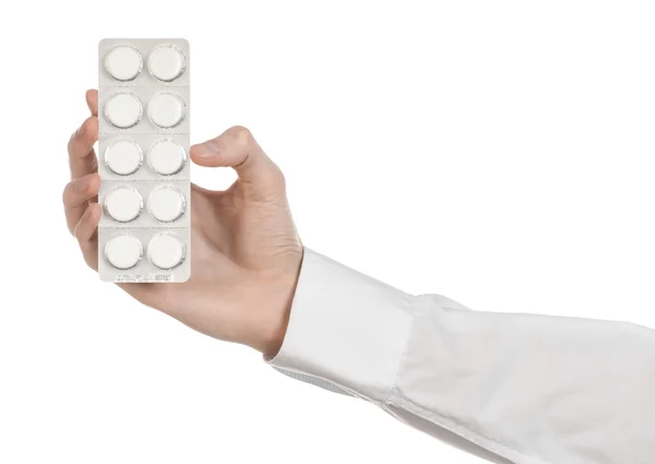 Tema médico: mão do médico segurando um comprimido branco para a saúde em um fundo branco isolado — Fotografia de Stock