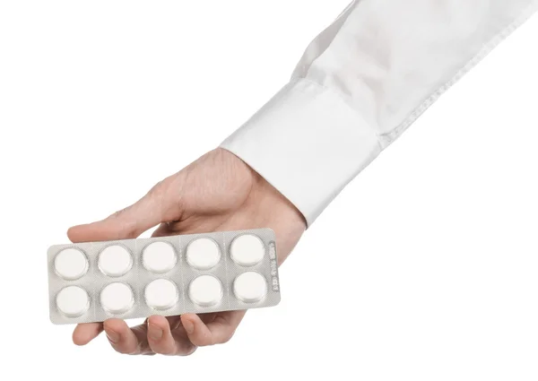 Tema médico: mão do médico segurando um comprimido branco para a saúde em um fundo branco isolado — Fotografia de Stock