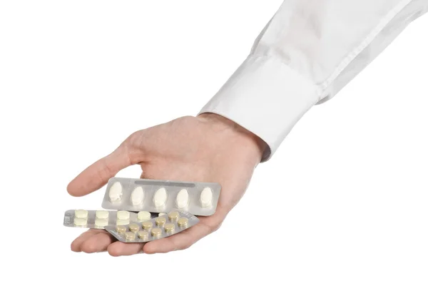 Tema médico: mano del médico sosteniendo una tableta blanca para la salud sobre un fondo blanco aislado — Foto de Stock