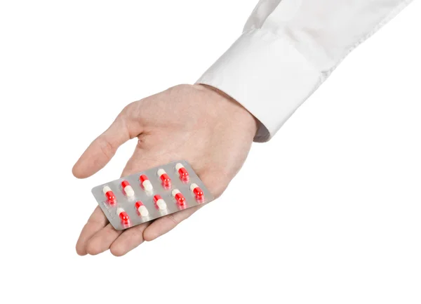 Medical theme: doctor's hand holding a red capsule for health on a white background isolated — Stock Photo, Image