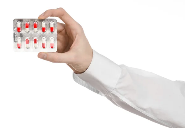 Medical theme: doctor's hand holding a red capsule for health on a white background isolated — Stock Photo, Image