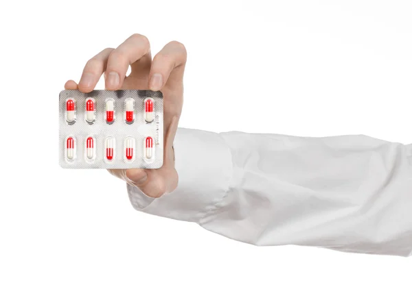 Medical theme: doctor's hand holding a red capsule for health on a white background isolated — Stock Photo, Image