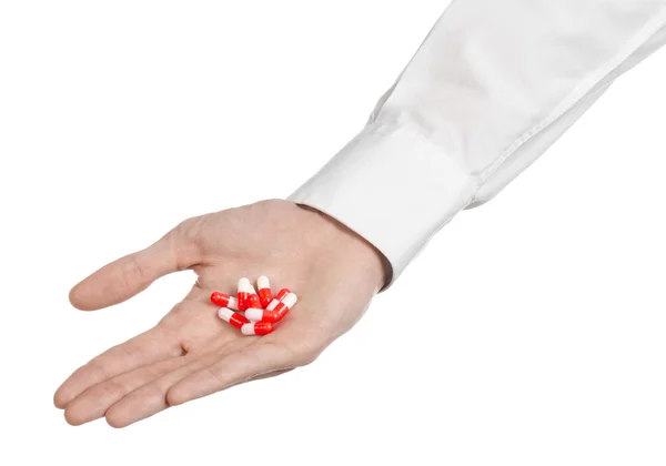 Medical theme: doctor's hand holding a red capsule for health on a white background isolated — Stock Photo, Image