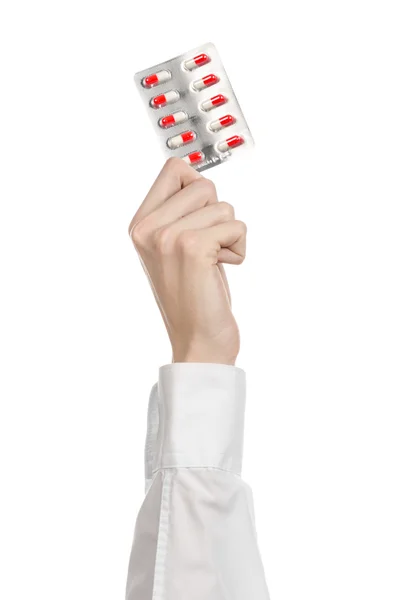 Medical theme: doctor's hand holding a red capsule for health on a white background isolated — Stock Photo, Image