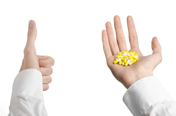 Medical theme: doctor's hand holding a yellow capsule for health on a white background isolated — Stock Photo, Image