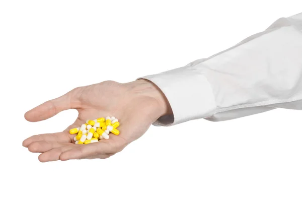 Medical theme: doctor's hand holding a yellow capsule for health on a white background isolated — Stock Photo, Image