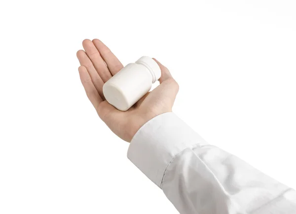 Tema médico: a mão do médico segurando um frasco branco vazio de pílulas em um fundo branco — Fotografia de Stock