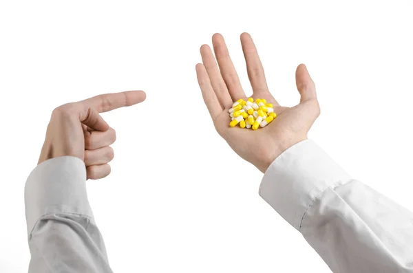 Medical theme: doctor's hand holding a yellow capsule for health on a white background isolated — Stock Photo, Image