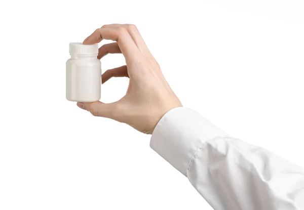 Медична тема: рука лікаря тримає білу порожню банку таблеток на білому тлі — стокове фото