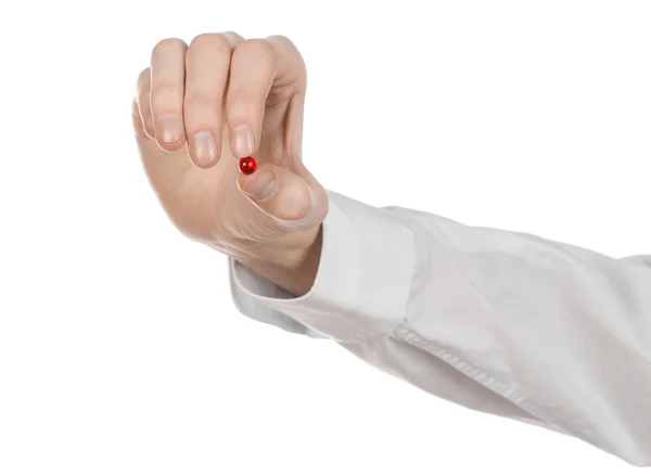 Medical theme: doctor's hand holding a red capsule for health on a white background isolated — Stock Photo, Image