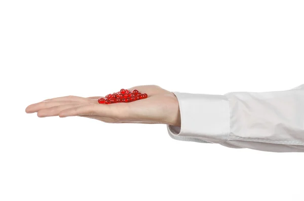 Medical theme: doctor's hand holding a red capsule for health on a white background isolated — Stock Photo, Image