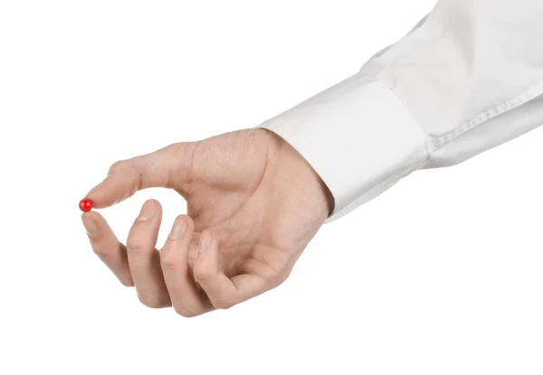 Tema médico: mão do médico segurando uma cápsula vermelha para a saúde em um fundo branco isolado — Fotografia de Stock