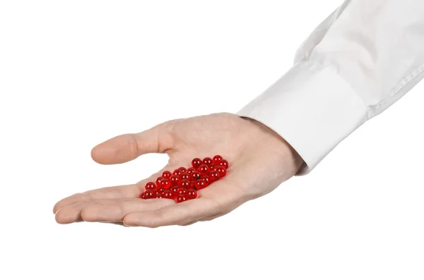 Medical theme: doctor's hand holding a red capsule for health on a white background isolated — Stock Photo, Image