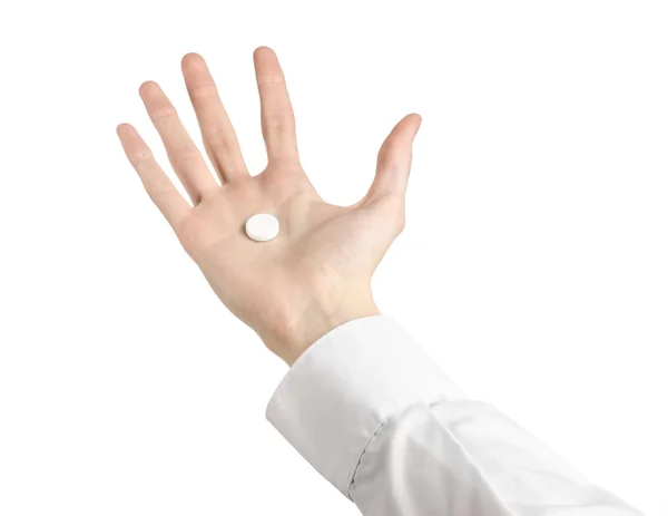 Medische thema: doctor's hand met een witte tablet voor gezondheid op een witte achtergrond geïsoleerd — Stockfoto