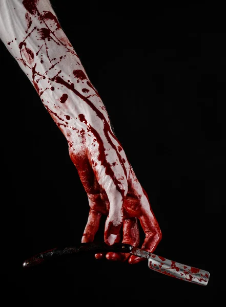 Bloody Halloween theme: bloody hand holds a razor sharp old with a dangerous edge isolated on black background — Stock Photo, Image