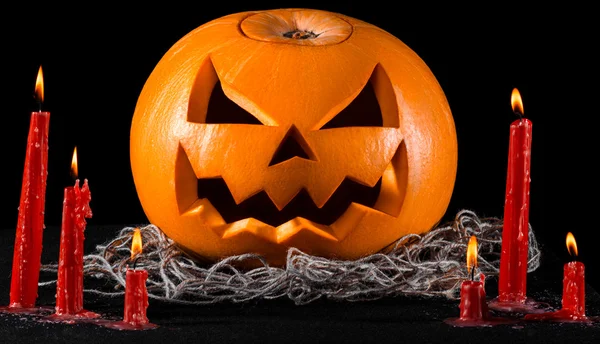 Eng pompoen, jack lantern, pompoen halloween, rode kaarsen op een zwarte achtergrond, halloween thema, pompoen moordenaar — Stockfoto