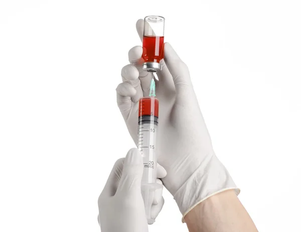 Медична тема: рука лікаря в білій рукавичці, що тримає червоний флакон рідини для ін'єкцій ізольовано на білому тлі — стокове фото