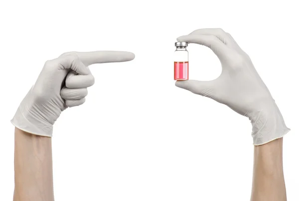 Medizinisches Thema: die Hand des Arztes in einem weißen Handschuh, der ein rotes Fläschchen mit Flüssigkeit für die Injektion auf weißem Hintergrund isoliert hält — Stockfoto