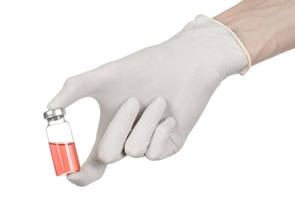 Medical theme: doctor's hand in a white glove holding a red vial of liquid for injection isolated on white background