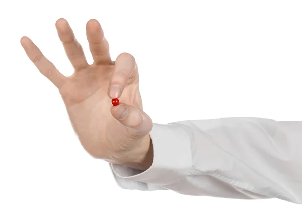 Medical theme: doctor's hand holding a red capsule for health on a white background isolated Stock Photo