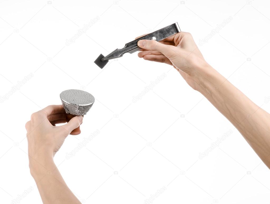 Hookah topic: Bartender holding a forceps with coal for hookah and puts them into a clay bowl isolated on white background