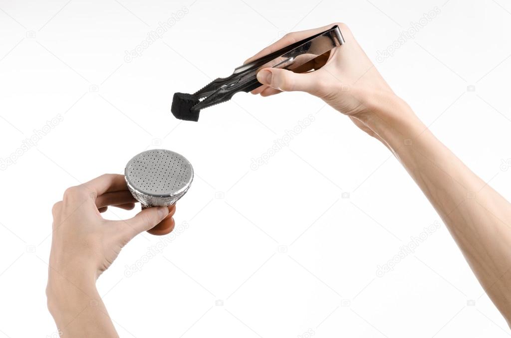 Hookah topic: Bartender holding a forceps with coal for hookah and puts them into a clay bowl isolated on white background