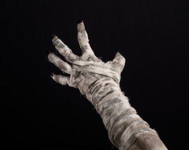 Halloween theme: terrible old mummy hands on a black background clipart