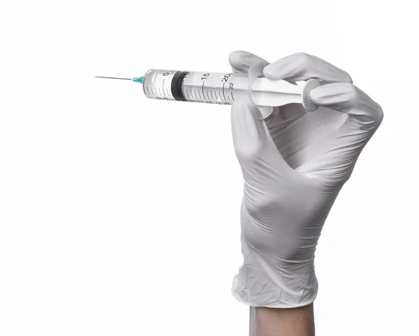 Läkarens hand håller en spruta, vita handskar handen, en stor spruta, medicinsk fråga läkaren gör en injektion, vit bakgrund, isolerade, vita handskar läkare Stockbild