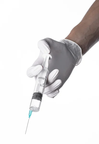 Doctor's hand met een injectiespuit, wit-gehandschoende hand, een grote spuit, medische kwestie, de arts maakt een injectie, witte achtergrond, geïsoleerd, witte handschoenen arts Stockfoto