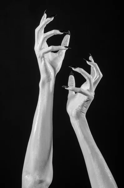 white hands of death with black nails, white death, the devil's hands, the hands of a demon, white skin, halloween theme, black background, isolated