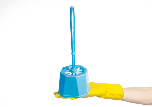 Cleaning the house and cleaning the toilet: human hand holding a blue toilet brush in yellow protective gloves isolated on a white background in studio