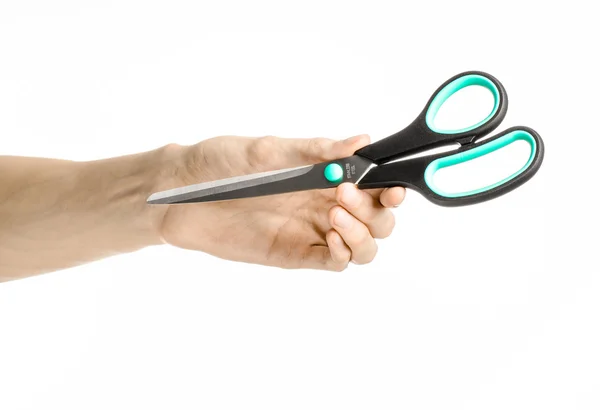 Office and home topic: human hand holding a black scissors with blue accents on a white isolated background in studio — Stock Photo, Image