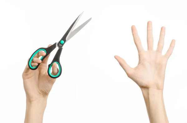 Office and home topic: human hand holding a black scissors with blue accents on a white isolated background in studio — Stock Photo, Image