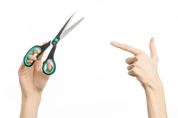 Office and home topic: human hand holding a black scissors with blue accents on a white isolated background in studio — Stock Photo, Image