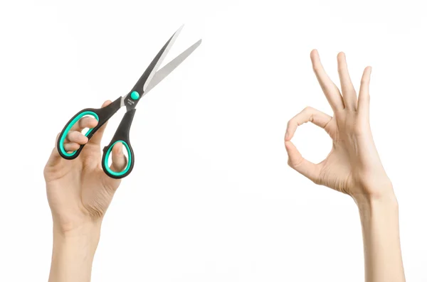 Office and home topic: human hand holding a black scissors with blue accents on a white isolated background in studio — Stock Photo, Image