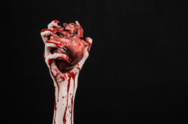 Kanlı korku ve Halloween Tema: korkunç kanlı eller kanlı insan kalbi tutan bir siyah arka plan üzerine siyah çivi ile izole Studio arka plan
