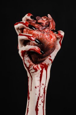 Kanlı korku ve Halloween Tema: korkunç kanlı eller kanlı insan kalbi tutan bir siyah arka plan üzerine siyah çivi ile izole Studio arka plan