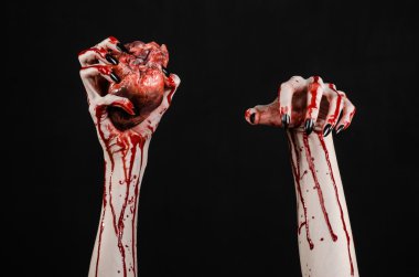 Kanlı korku ve Halloween Tema: korkunç kanlı eller kanlı insan kalbi tutan bir siyah arka plan üzerine siyah çivi ile izole Studio arka plan