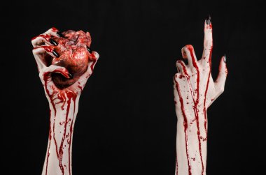 Kanlı korku ve Halloween Tema: korkunç kanlı eller kanlı insan kalbi tutan bir siyah arka plan üzerine siyah çivi ile izole Studio arka plan