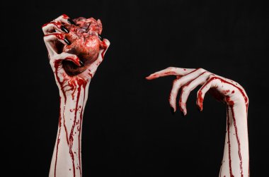 Kanlı korku ve Halloween Tema: korkunç kanlı eller kanlı insan kalbi tutan bir siyah arka plan üzerine siyah çivi ile izole Studio arka plan